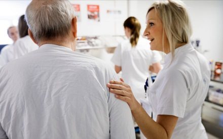 Sygeplejerske med hånden hvilene på patients arm
