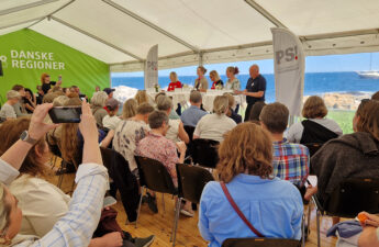 Paneldebat i Danske Regioners telt på Folkemødet 2025. Et fyldt telt, hvor der på bagvæggen er udsigt til havet.