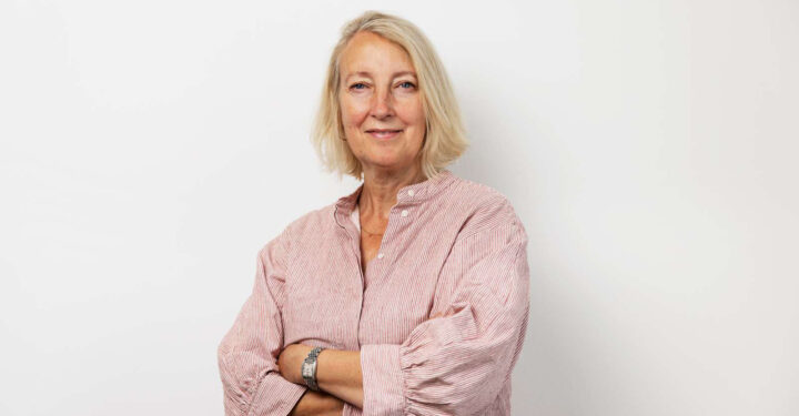 Portræt af PS!-direktør Inge Kristensen med et smil på læben og armene over kors.