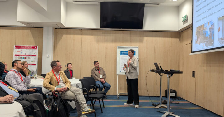 Kvinde står og taler foran et publikum